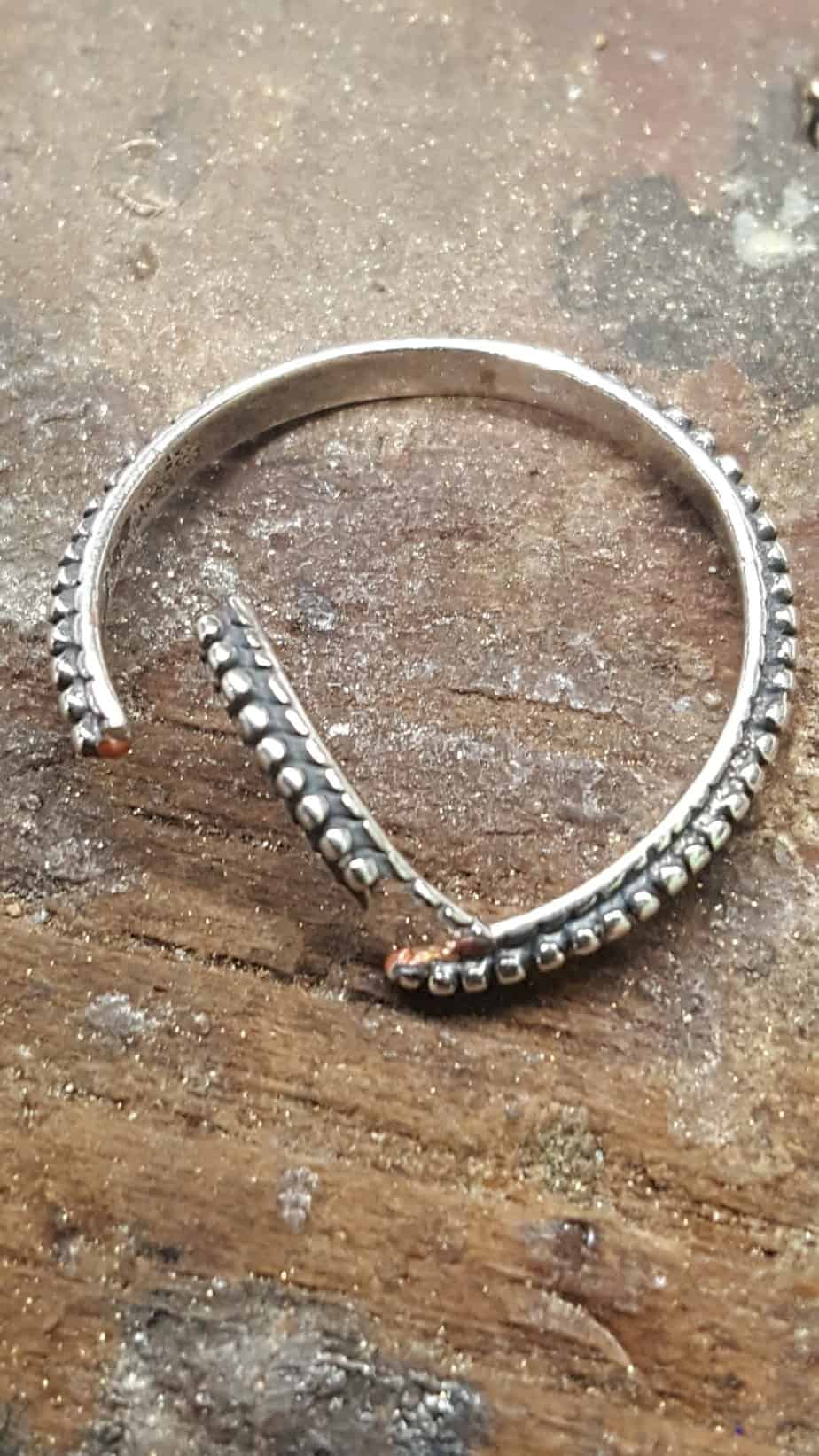 A silver cuff on the workbench